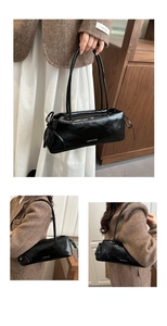 Detail of black bow shoulder bag with white lettering on premium glossy finish