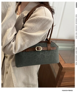 Detail of leopard embossed suede shoulder bag with brown leather strap and gold buckle