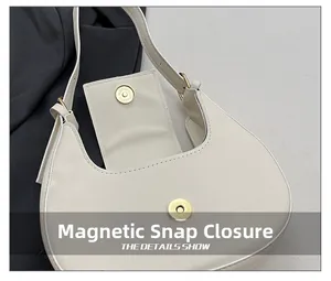 Detail of the magnetic closure on a cream crescent bag with minimalist hardware