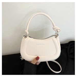 Detail of cream white half-moon bag featuring a knotted handle and silver ring hardware