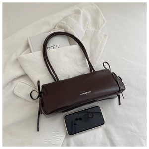Chocolate brown baguette bag with bow drawstring detail and smartphone for size reference