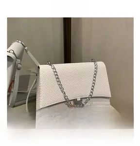 Vue détaillée du sac blanc avec tissu texturé, chaîne argentée et boucle en forme de B