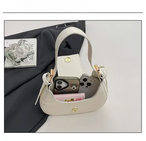Internal view of cream crescent bag showing capacity for two phones and a wallet