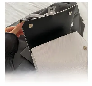 Détail du sac en tissu à chevrons blanc avec intérieur en cuir noir et boucle métallique en B