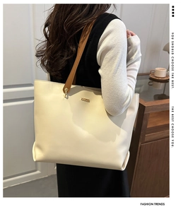 Detail of premium PU leather tote bag in cream white with brown handles and golden hardware
