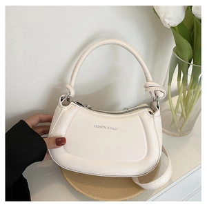 Detail of cream white crescent bag with knotted handle and fashion lettering