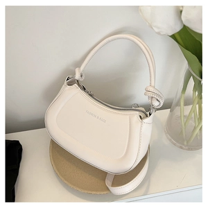 Detail of cream crescent bag with knotted handle and Fashion & Bags text on PU leather