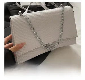 Détail d'un sac blanc à texture diagonale avec boucle métallique argentée en B