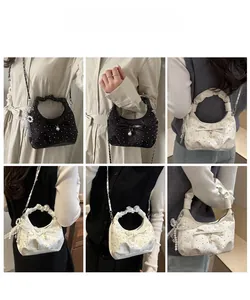 Detailed views of pleated shoulder bag with satin bow and pearl charms on model