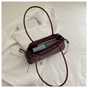 Macro view of burgundy leather underarm bag interior showing storage space for daily items