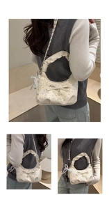 Macro detail of creamy white hobo bag with pearl bow charms and pleated handle texture