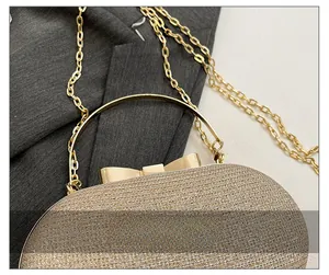 Detail of glitter evening bag featuring champagne gold sequins and metallic bow clasp