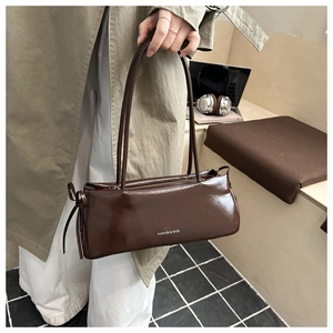 Detail showing brown faux leather baguette bag with side bow and fashion lettering