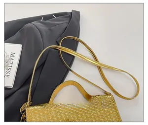 Detail of adjustable slim shoulder strap on golden woven leather handbag