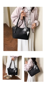 Detail of black pebbled leather tote bag with heart pattern scarf and shoulder strap