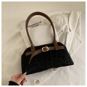 Close-up of leopard print shoulder bag on corduroy jacket with gold metal buckle detail