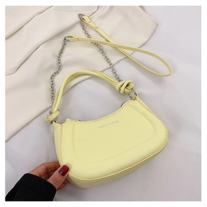 Detail of lemon yellow crescent bag with knotted handle and silver chain strap