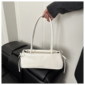 Close-up of white PU leather underarm bag featuring side bows and fashion print