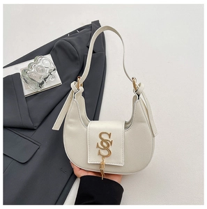 Detailed close-up of a white crescent shoulder bag with golden S logo and metal tassel