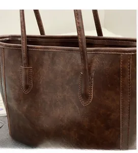 Close-up of retro cracked texture on dark brown tote bag with premium stitching detail