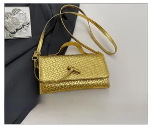 Detailed comparison of the golden woven handbag size with a smartphone reference