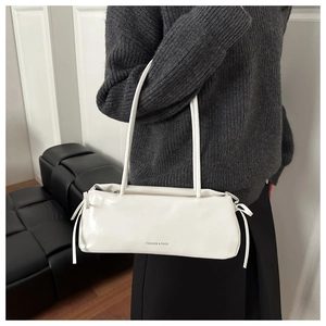 Dettaglio della borsa a spalla in pelle bianca con fiocchi laterali e scritta Fashion
