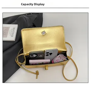 Detail view showing internal capacity of gold woven leather bag with phones and wallet