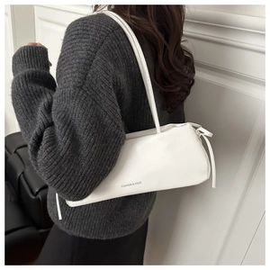 Detailed view of a white minimalist shoulder bag with FASHION & BAGS logo and strap detail
