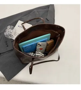 Spacious interior of brown leather tote bag showing storage for tablet and daily items