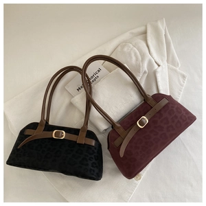 Detail of retro shoulder bags in black and wine red with leopard velvet and leather handles