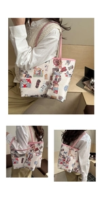Detail of canvas tote bag featuring graffiti art, pink leather straps and a small pouch