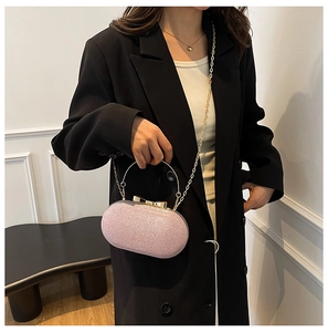 Polished pink glitter evening clutch bag with golden metal handle and bow clasp detail