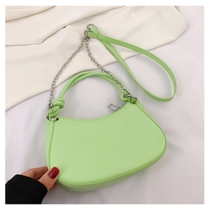 Detail of mint green crescent bag with knotted handle and silver chain decoration