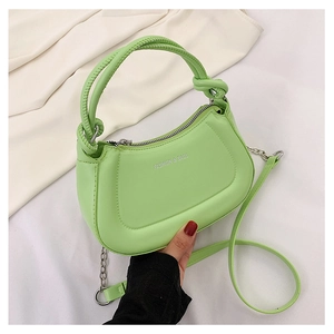 Detail of light green half-moon crossbody bag with knot handle and chain strap