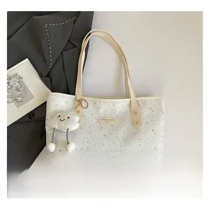 Sac cabas en toile blanche avec étoiles argentées, anses en cuir jaune et bijou nuage