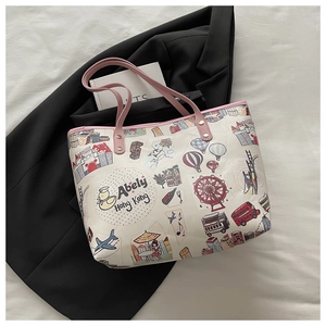 Detail of cartoon printed tote bag with pink handles and reinforced rivets on white fabric