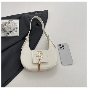 Detailed close-up of white leather hobo bag with gold tassel and interlocking SS logo