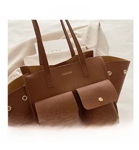 Dettaglio della borsa tote in pelle marrone motivo litchi con bottoni dorati e logo