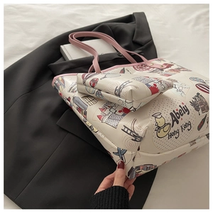 Detail of white tote bag set with cute cartoon illustrations and pink shoulder straps