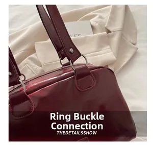 Détail du sac cabas bordeaux brillant avec anneaux métalliques et rivets de fixation