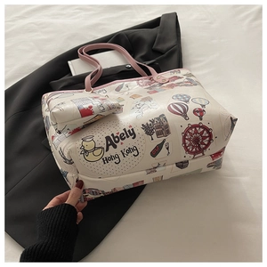 Detail of white tote bag set with pink trim and colorful cartoon graffiti patterns