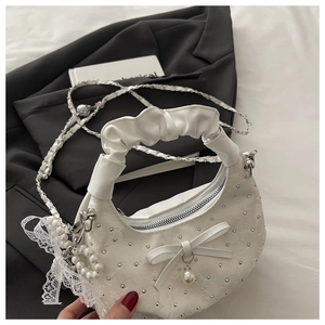 Detail of white satin hobo bag with silver studs, bow, pearl charm and chain strap