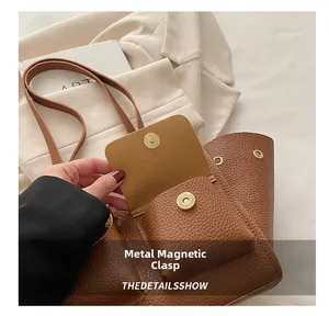 Dettaglio macro della chiusura magnetica dorata sulla borsa tote in pelle marrone