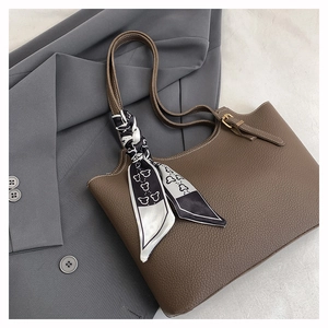 Detail of dark brown lychee leather tote bag with stylish printed silk scarf and metal buckle