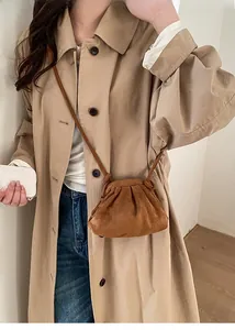 Borsa a nuvola plissettata in camoscio marrone indossata da una modella in studio
