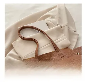 Borsa tote in pelle litchi marrone con logo dorato e raffinati dettagli con occhielli