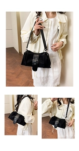 Détail du sac bandoulière noir avec boucle argentée et texture en nylon lisse