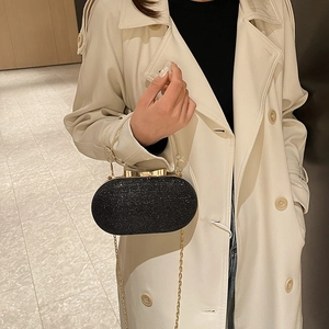 Sparkly black sequin evening clutch bag with golden bow clasp and metal handle