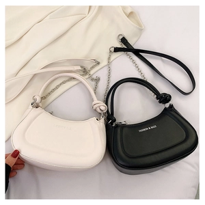 Detail of hobo bags with metal chains and adjustable straps in black and cream leather