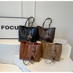 Detailed view of large vintage tote bags in four colors with bunny charms and long straps